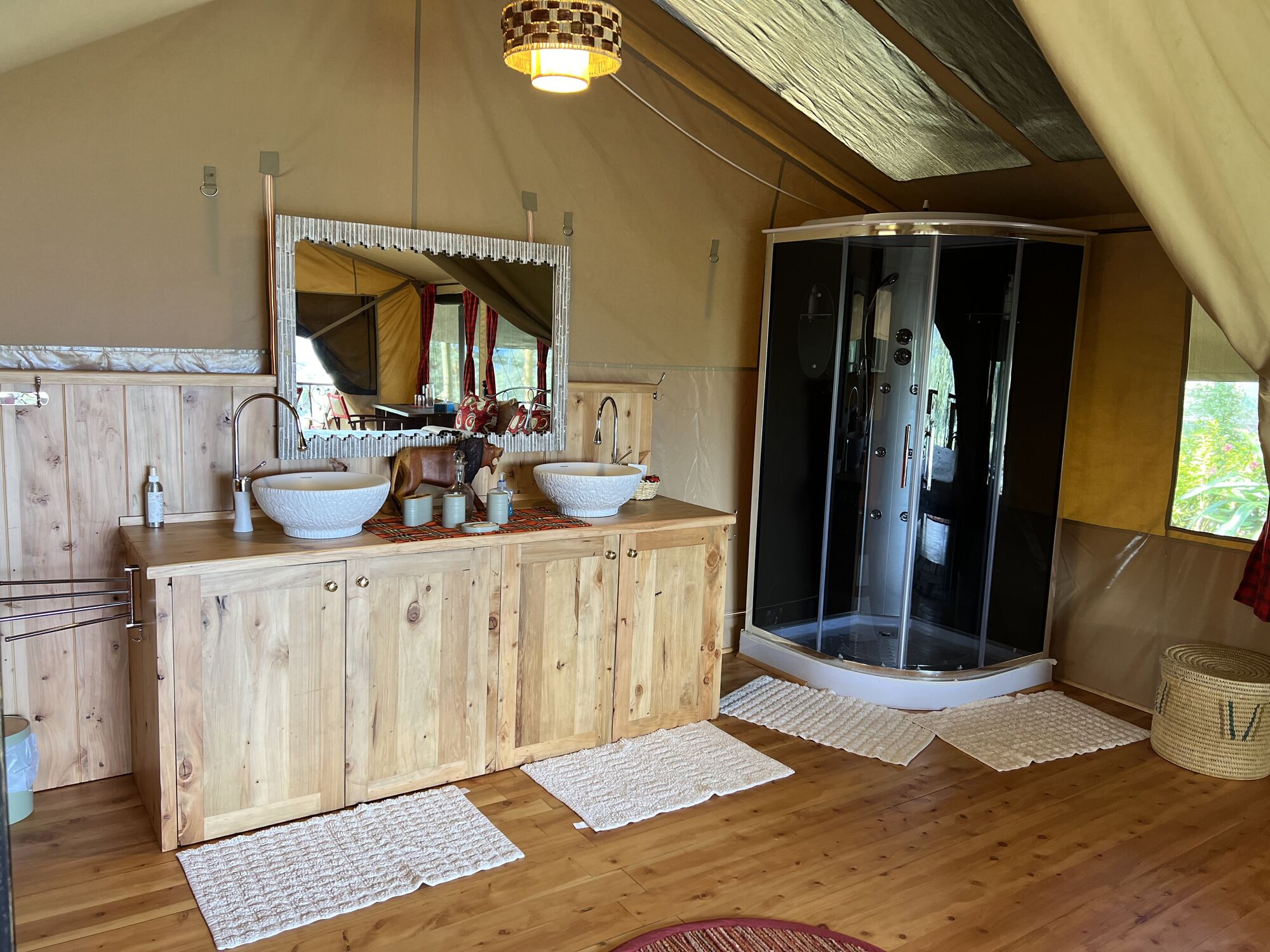 Bathroom inside a safari tent with twin basins and a shower