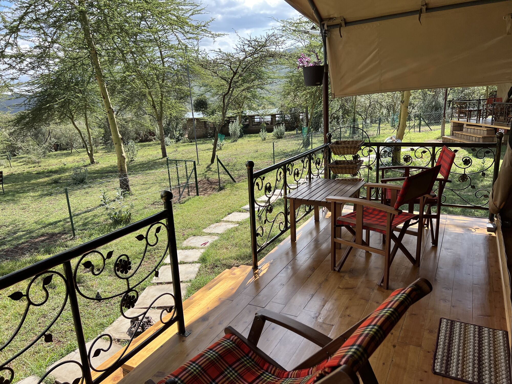 Tent veranda with a table and chairs overlooking the farm